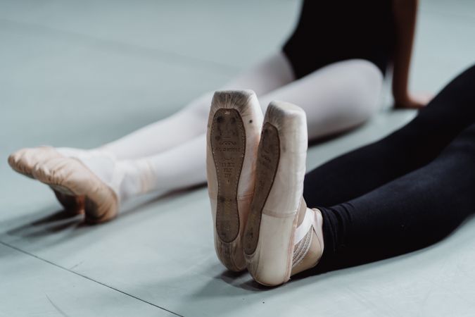 Two ballet dancers stretching on the floor