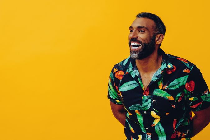 Excited male smiling in brightly patterned shirt, copy space