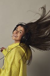 Shocked young woman listening to music in studio