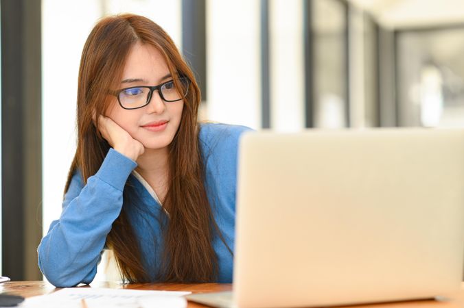 Asian woman looking at laptop on the desk for an online meeting in the office