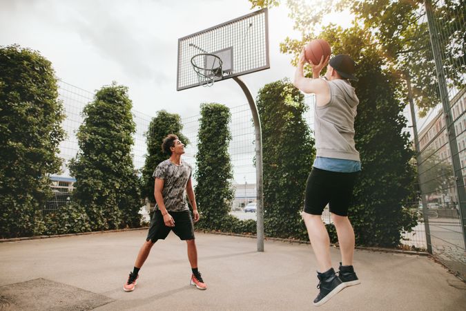 Two friends playing basketball on court