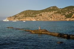 Woman doing yoga on rocky pier