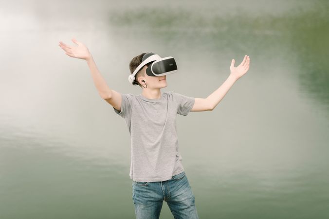 Young teenager with virtual reality glasses outdoors