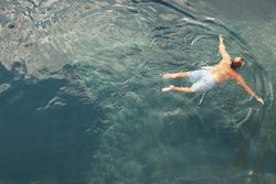 Man swimming in blue water