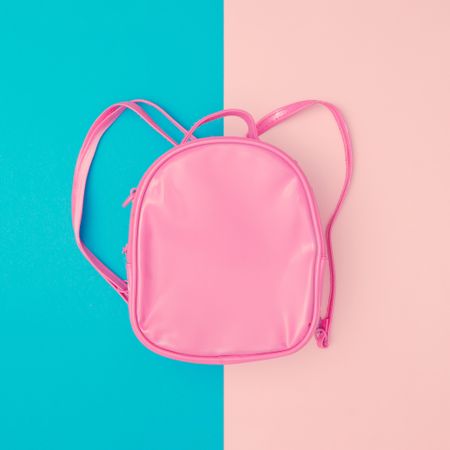 Pink school bag on minimal pastel pink and blue background