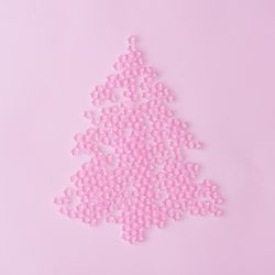 Christmas tree made of pink star decoration on pastel pink background