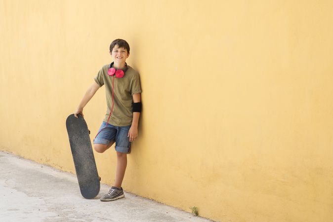 A teenage boy with skateboard on the city street