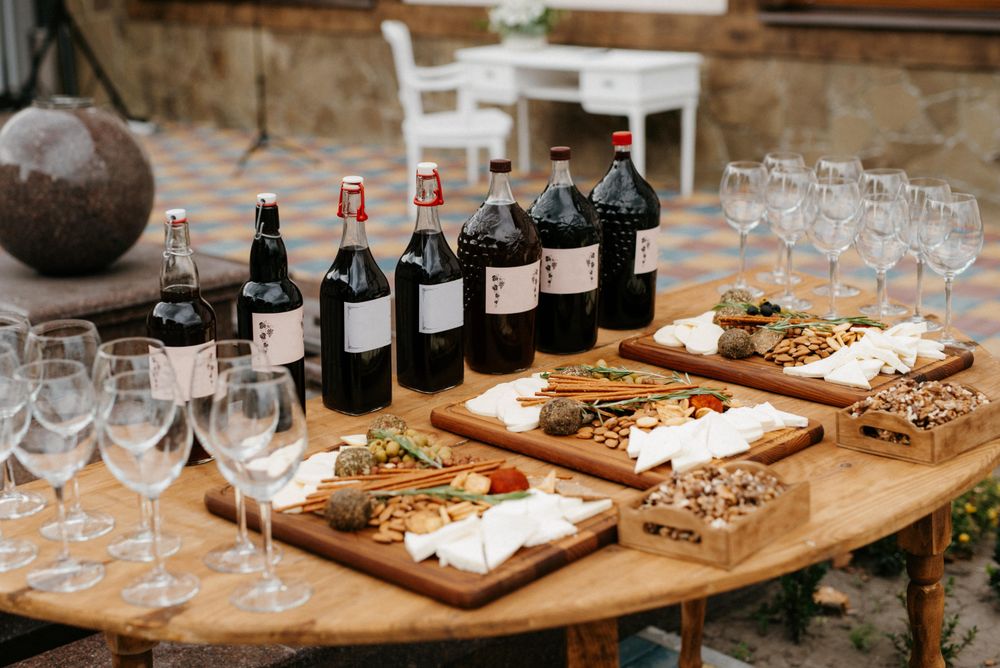 Wine bottles and variation of aged cheese on brown wooden table