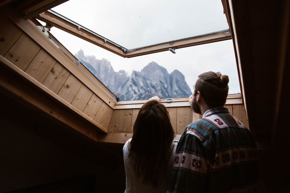 Resting couple in casual wear enjoying views from ceiling window