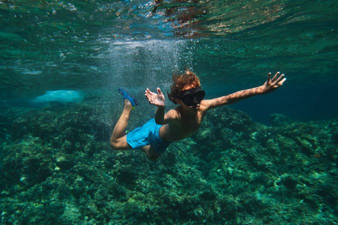 Boy in goggles swimming in ocean