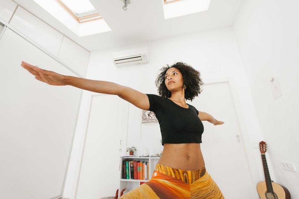 Sportive woman standing in yoga pose stretching arms