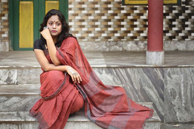 Woman wearing sari sitting on steps