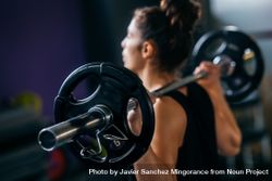 Fit woman with barbell over her shoulders 5RGAW4