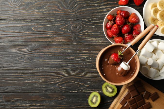Composition with ingredients for chocolate fondue on wooden background. Cooking fondue