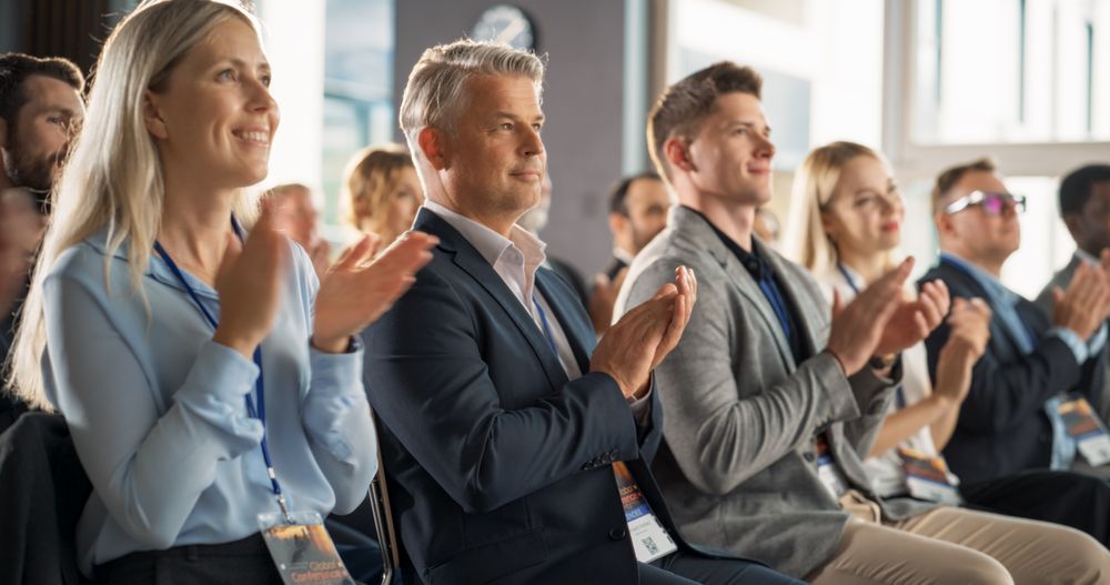 Male CEO Sitting in a Bright Crowded Auditorium at a Tech Conference. Confident Man Applauding After a Successful Keynote Presentation. Specialist Inspired by Latest Technological Advances.