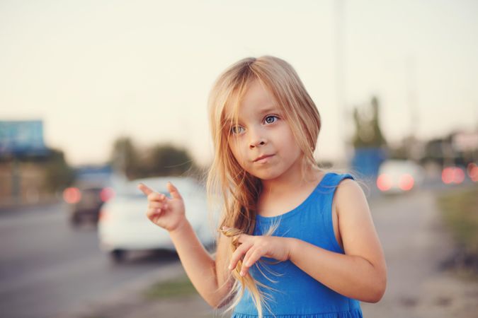 Female child standing with cars in background