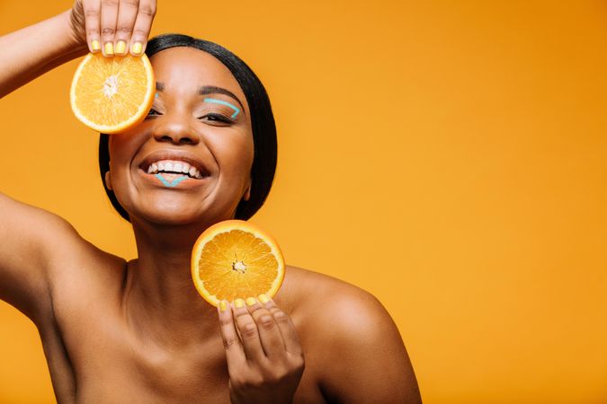 Woman smiling with orange slices in hand
