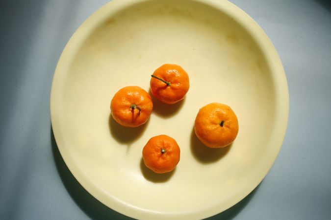 Top view of four clementines on a plate