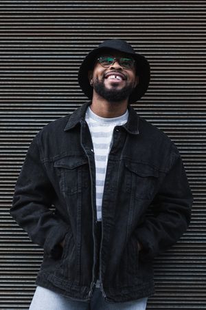 Smiling Black hipster man in hat looking at camera