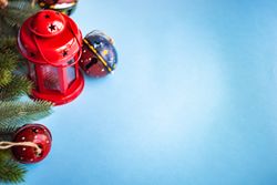Christmas festive concept of red lantern, bells nestled in branches on blue background