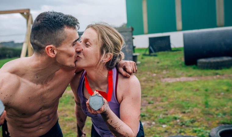 Athletes kissing and showing medals
