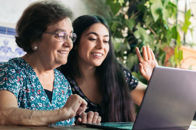 Grandmother and granddaughter making video call with laptop
