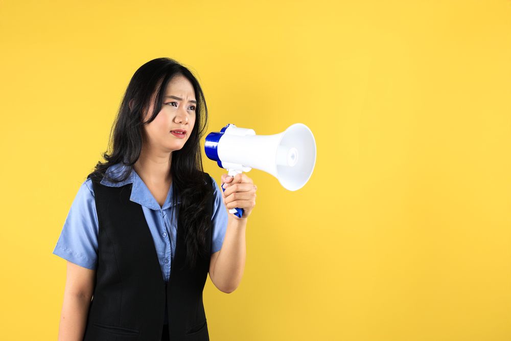 Upset Young Asian Female Holding A Megaphone, Trying to Deliver a Protest Message