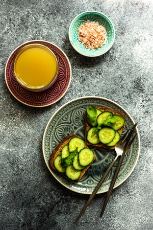 Top view of healthy lunch with vegetable cucumber toast on grey counter