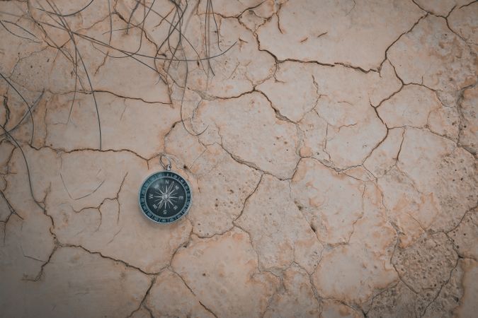 Big compass on dry cracked desert area