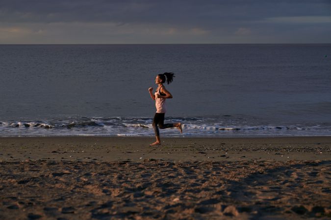 Woman running along sea during training