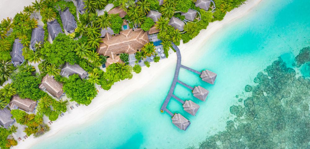 Overhead shot of various bungalows on an island resort, wide