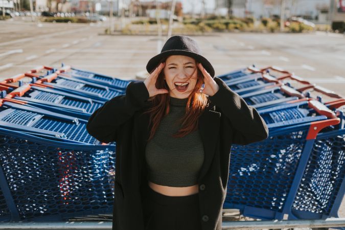 Woman screaming in parking lot with shopping carts