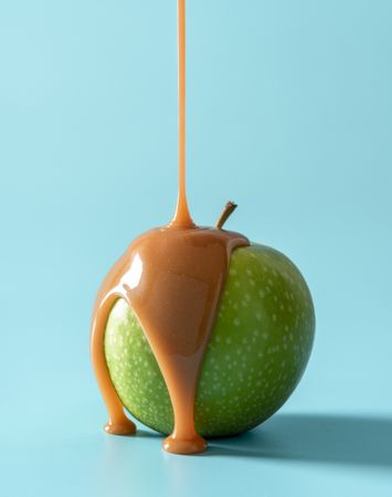 Caramel apple on blue background