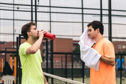 Two paddle tennis players resting after a game