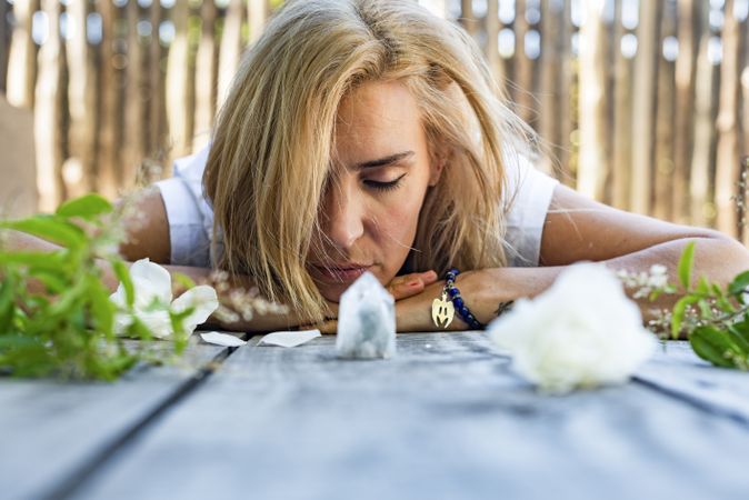 Portrait of a woman lying on the floor with her eyes closed with crystals
