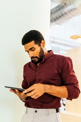 Handsome Latino man working with a tablet in a coworking