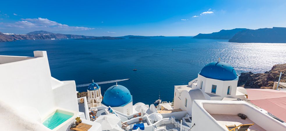Wide shot of blue topped domes over looking the Aegean Sea