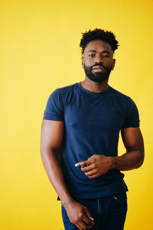 Portrait of Black man standing in navy t-shirt and jeans in studio shoot