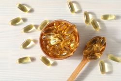 Omega pills in a wooden bowl on a neutral background