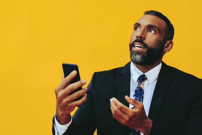 Serious Black businessman having a video call on a smartphone screen while looking up