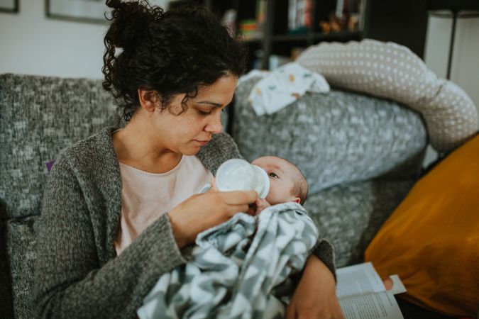 Woman bottle feeds a newborn