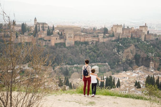 Back of mother and daughter overlooking beautiful Spanish town