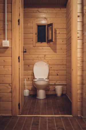Bathroom in wooden house with opened door