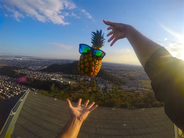 Person throw pineapple with sunglasses