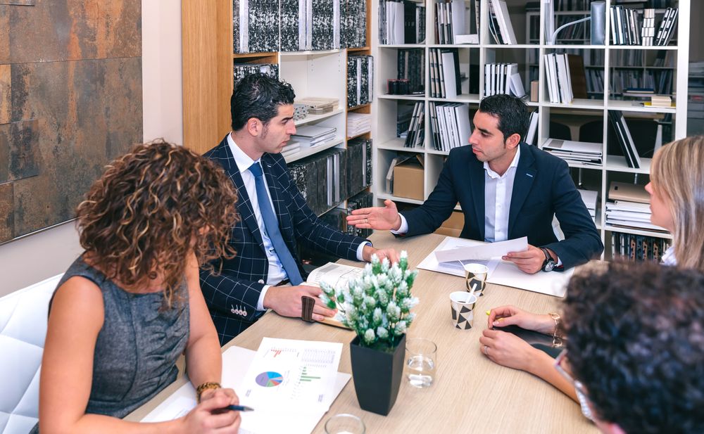 Colleagues discussing graphs in a business meeting in office