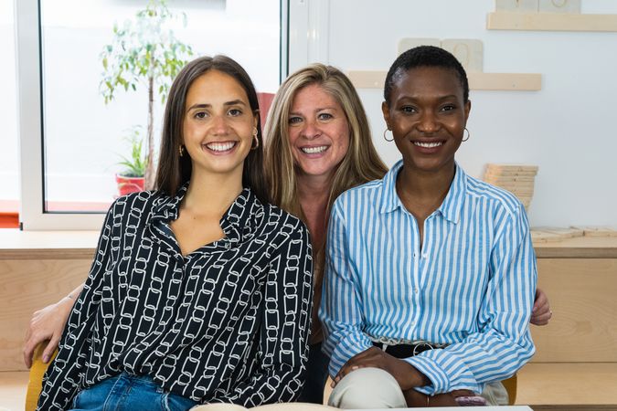 Cheerful diverse coworking women looking at camera