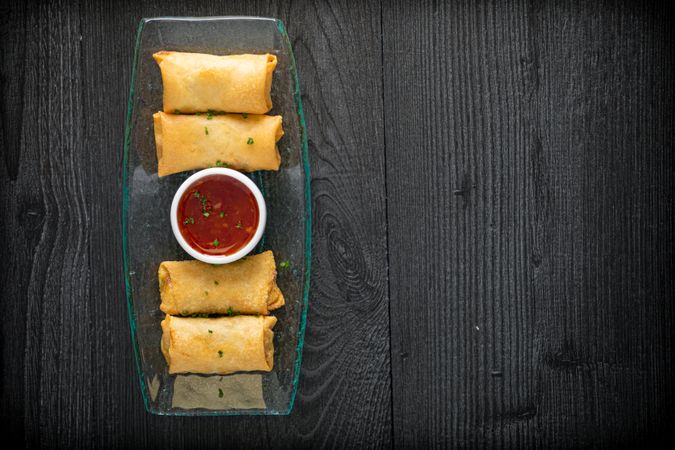 Vietnamese rolls with sweet chili on glass plate