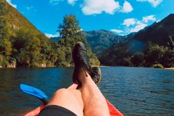 Faceless person relaxing on boat on nature background