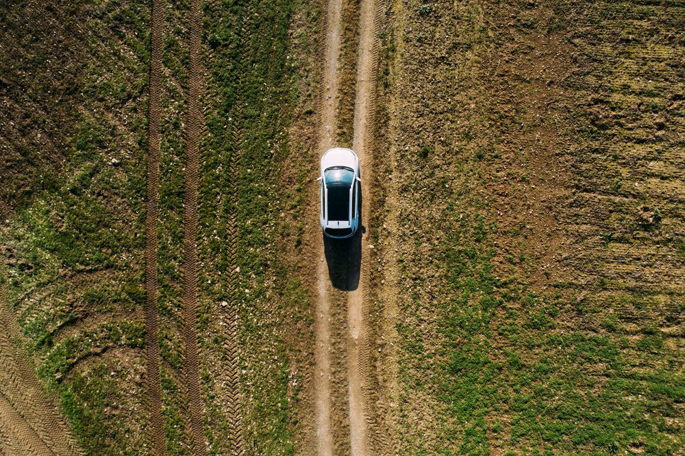 Aerial view of a car crossing a dirt road