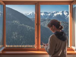 Woman browsing smartphone near window
